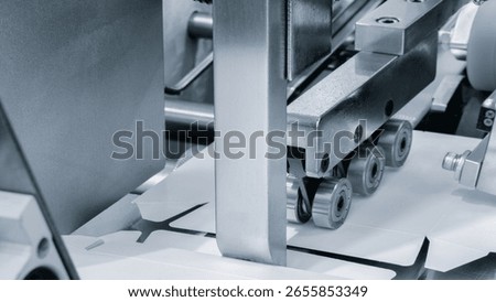 Elements of cardboard boxes are collected in stack. Conveyor line for the production of boxes. Machine cuts cardboard boxes from sheets of cardboard. Enterprise for  production package.