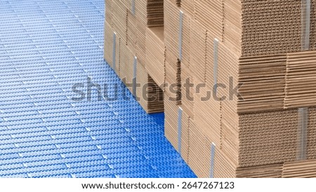 Elements of corton boxes are collected in stack. Conveyor line for the production of boxes. Machine cuts cardboard boxes from sheets of cardboard. Enterprise for the production package.