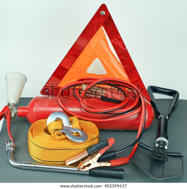 Elements of the essentials for a\
passenger car. Danger Safety Warning Triangle Sign, towing rope,\
fire extinguisher, Jumper cable, wheel wrench and\
shovel.