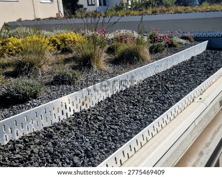 elements extensive green roof.Deck strip aluminum profile with holes separates vegetation layer gravel ventilate drain edge roof. studded foil under substrate, retains water excess rainwater to drain.