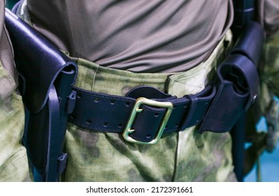 Elements of military ammunition on a dummy.Black military belt on camouflage trousers along with a holster. Demonstration of military uniforms at the exhibition.