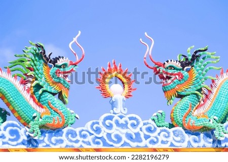 Elements of Thai Temple sculpture: dragon, three-faced janus, samsara, solstice, elephant, symbols of power, caitya, etc. Ecclesiastical luxury. Emblem oriental dragons against the blue sky harmonize