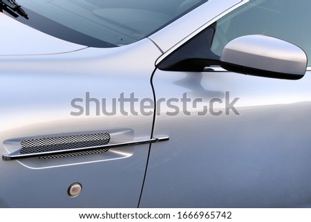 Elements of White Modern Luxury car. Rearview mirror and radiator grid closeup.