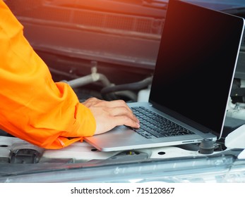 Elephant Man using laptop for checking a car engine.