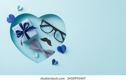 Elevate Father's Day wishes with a chic top view arrangement of bow tie, mustache, giftbox and more, showcased against a pastel blue backdrop. Heart-shaped cutout adds a loving detail - Powered by Shutterstock