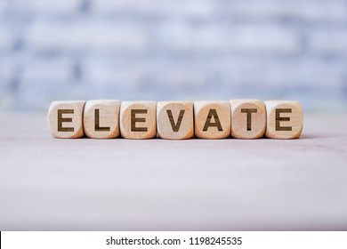 Elevate Word Written On Wood Block