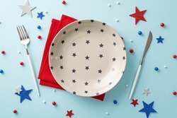 Elevate Your Independence Day Celebration With Patriotic Table Arrangement. Top View Of Plate, Silverware, Napkin, Sprinkles, Stars On Pastel Blue Background. Customize Space With Your Own Text Or Ad
