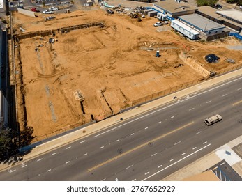 An elevated drone perspective captures the extensive site preparation and earthmoving at Surfside Educational Academy, located at the intersection of Oceanside Boulevard and Ditmar Street in Oceanside, California. Funded by the Measure W bond, this modernization project involves the demolition of older structures and the grading of the campus for new facilities, including administration buildings and modern classrooms. The footage shows heavy machinery active on the grounds of the historic former Ditmar Elementary site, documenting a significant phase of public school infrastructure.