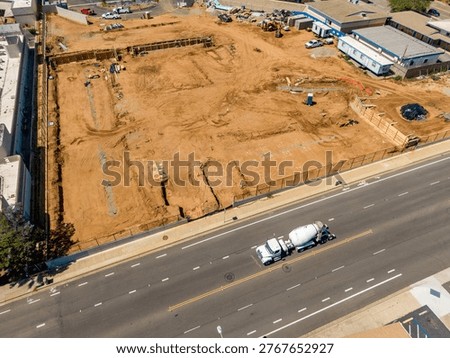 An elevated drone perspective captures the extensive site preparation and earthmoving at Surfside Educational Academy, located at the intersection of Oceanside Boulevard and Ditmar Street in Oceanside, California. Funded by the Measure W bond, this modernization project involves the demolition of older structures and the grading of the campus for new facilities, including administration buildings and modern classrooms. The footage shows heavy machinery active on the grounds of the historic former Ditmar Elementary site, documenting a significant phase of public school infrastructure.