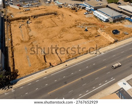 An elevated drone perspective captures the extensive site preparation and earthmoving at Surfside Educational Academy, located at the intersection of Oceanside Boulevard and Ditmar Street in Oceanside, California. Funded by the Measure W bond, this modernization project involves the demolition of older structures and the grading of the campus for new facilities, including administration buildings and modern classrooms. The footage shows heavy machinery active on the grounds of the historic former Ditmar Elementary site, documenting a significant phase of public school infrastructure.