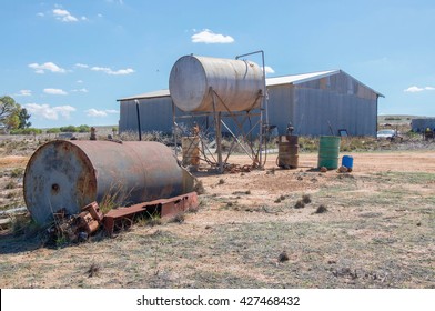 Elevated Fuel Tank, Rusted Barrel And Pole Building In Western Australia Farmland Under A Blue Sky/Farm Scene/Agriculture In Western Australia