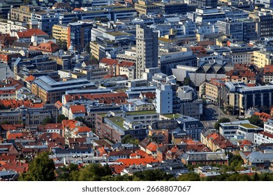 An elevated, high-angle view captures a sprawling urban landscape, showcasing a fascinating blend of architectural styles. 