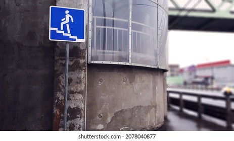 An Elevated Pedestrian Crossing With Signage On The Left. Overhead Crosswalk Over And Expressway