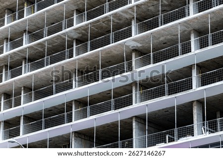 Elevated perspective of a construction site featuring workers on various floors, showcasing the structural development of an apartment building.