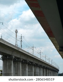 Elevated Railway Viaduct with Dramatic Cloudy Sky and Urban Road