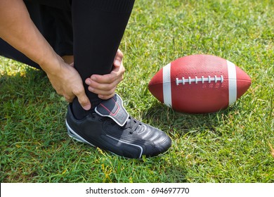 Elevated View Of American Football Player With Pain In His Ankle On Field