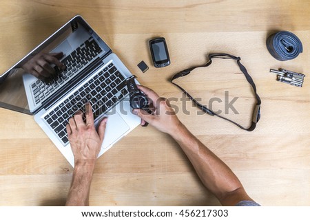 Elevated view of desk with hands, laptop, sports watch and gps device