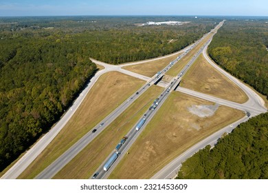 Elevated view of freeway exit junction over road lanes with fast moving traffic cars and trucks. Interstate transportation infrastructure in USA