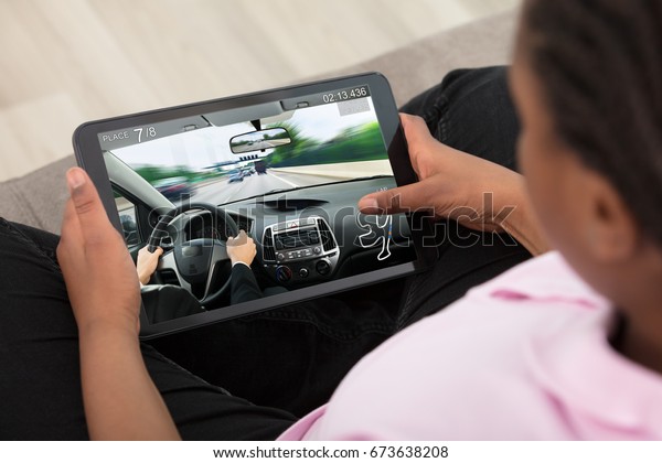 Elevated View Of A Girl Playing Car Race Game On\
Digital Tablet
