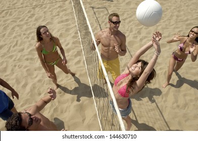 Elevated view of a group of young people playing volleyball on beach