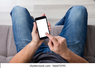 Elevated View Of A Man Sitting On Couch Using Cell Phone