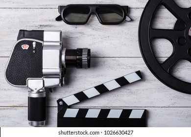 Elevated View Of Movie Camera, 3d Glasses, Film Reel And Clapper Board On Wooden Plank