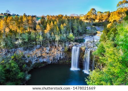 Elevated view over Dangar falls in Dorrigo National park near Dorrigo town in morning soft light with smooth water stream falling down to rock pool cut by millions of years erosion over lava plateau.