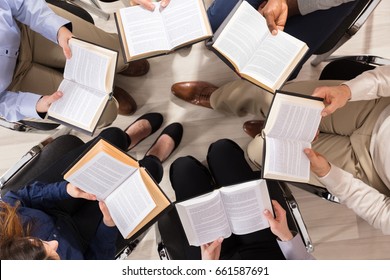 Elevated View Of People Sitting On Chair In Circle Reading Books