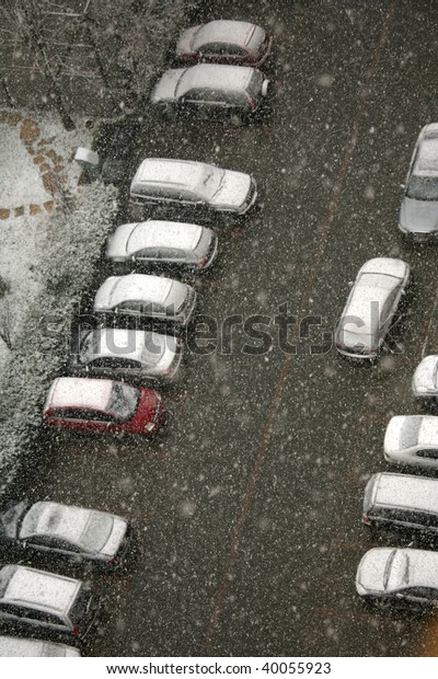 elevated view of\
snow covered cars in parking\
lot