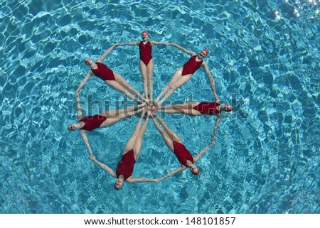 Elevated view of synchronised swimmers forming a circle in pool