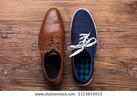 Elevated View Of Two Different Shoe On Wooden Background