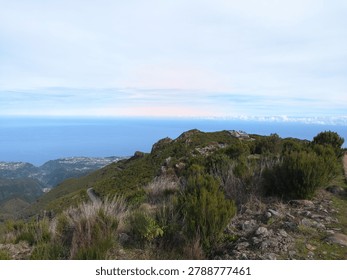 Elevated viewpoint overlooking mountains and the distant sea.