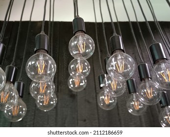 An Elevation View Of Several Identical Circular Light Bulbs Hanging From The Ceiling. It Was Switched Off And Not Activated.