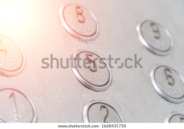 Elevator buttons with Braille close-up,\
Photo with\
illumination
