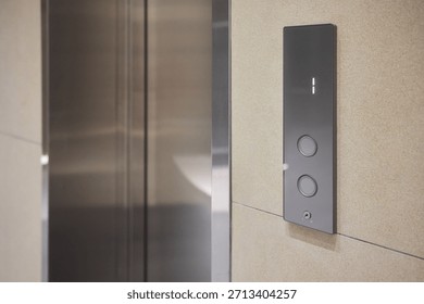 Elevator control panel displaying floor , brushed steel doors, beige wall, illuminated numeric display, round tactile buttons, soft ambient corridor lighting,