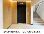 Elevator in the lobby hall of an apartment building. Modern decor and wood finishing of the ground floor and entrance.