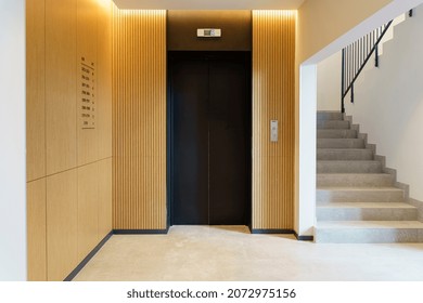 Elevator In The Lobby Hall Of An Apartment Building. Modern Decor And Wood Finishing Of The Ground Floor And Entrance.