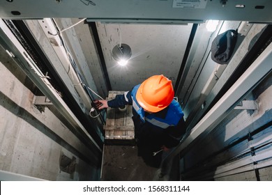 Elevator operator in the Elevator shaft makes repairs