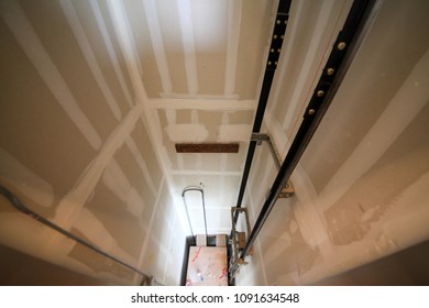 Elevator shaft with elevator rails installed and drywall walls