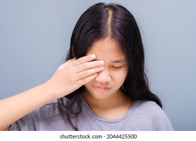 Eleven years old girl has a problem with her eye, suffering from irritation, and try to cover it with her hand