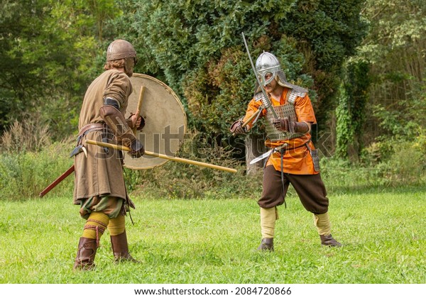 Elewijt, Zemst, Belgium 25\
September 2021 : Knight soldiers fighting in battle with knife,\
axe, sword, stick and shield and wearing helmet during mediavel\
reenactment