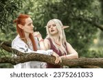 An elf man and an elf woman are standing near a tree. A pair of stunning detailed elven fantasies, mythical fairy tale characters.