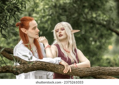 An elf man and an elf woman are standing near a tree. A pair of stunning detailed elven fantasies, mythical fairy tale characters.