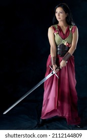 An Elf Warrior Queen Wearing A Laced Bodice And Draped Skirt And Holding A Sword