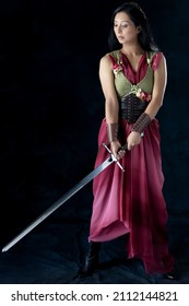 An Elf Warrior Queen Wearing A Laced Bodice And Draped Skirt And Holding A Sword