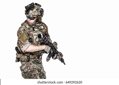 Elite member of US Army rangers in combat uniforms with his shirt sleeves rolled up, in helmet, eyewear and night vision goggles, in turning around in action. Studio shot, white background