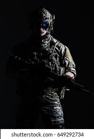 Elite member of US Army rangers in combat helmet and night vision device. Studio shot, dark black background, looking at camera, dark contrast