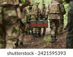 Elite military unit, cloaked in camouflage, transports a crate of ammunition through the dense forest, epitomizing strategic readiness and precision in their covert mission