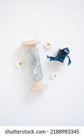 Elite Ribbons For The Holiday. Wedding Decoration Element, A Blue Silk Wide Ribbon Next To A Small Blue Ribbon On A Wooden Role Lies On A White Background With Small Flowers