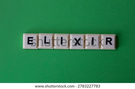 Elixir Word Spelled with Plastic Letter Tiles on Green Background